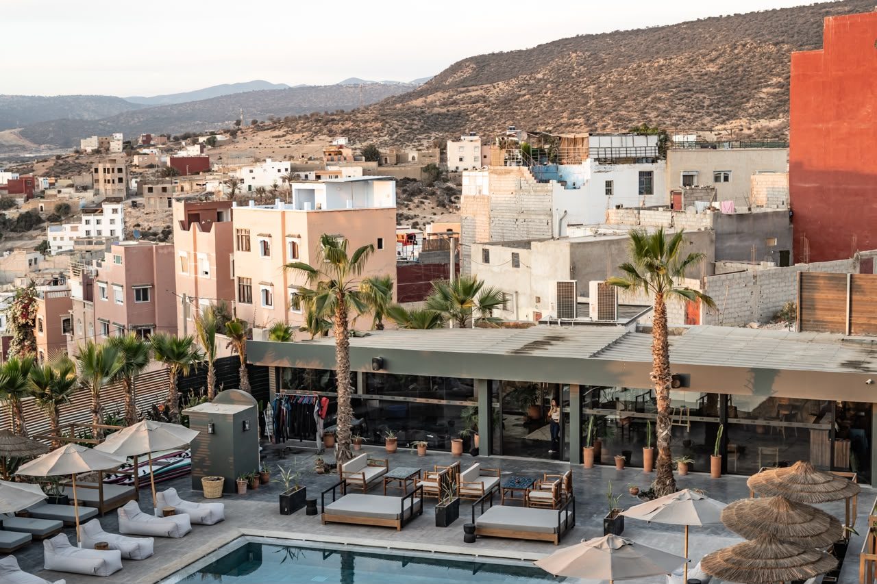 The beach club pool and loungers on Taghazout Bay with the village behind