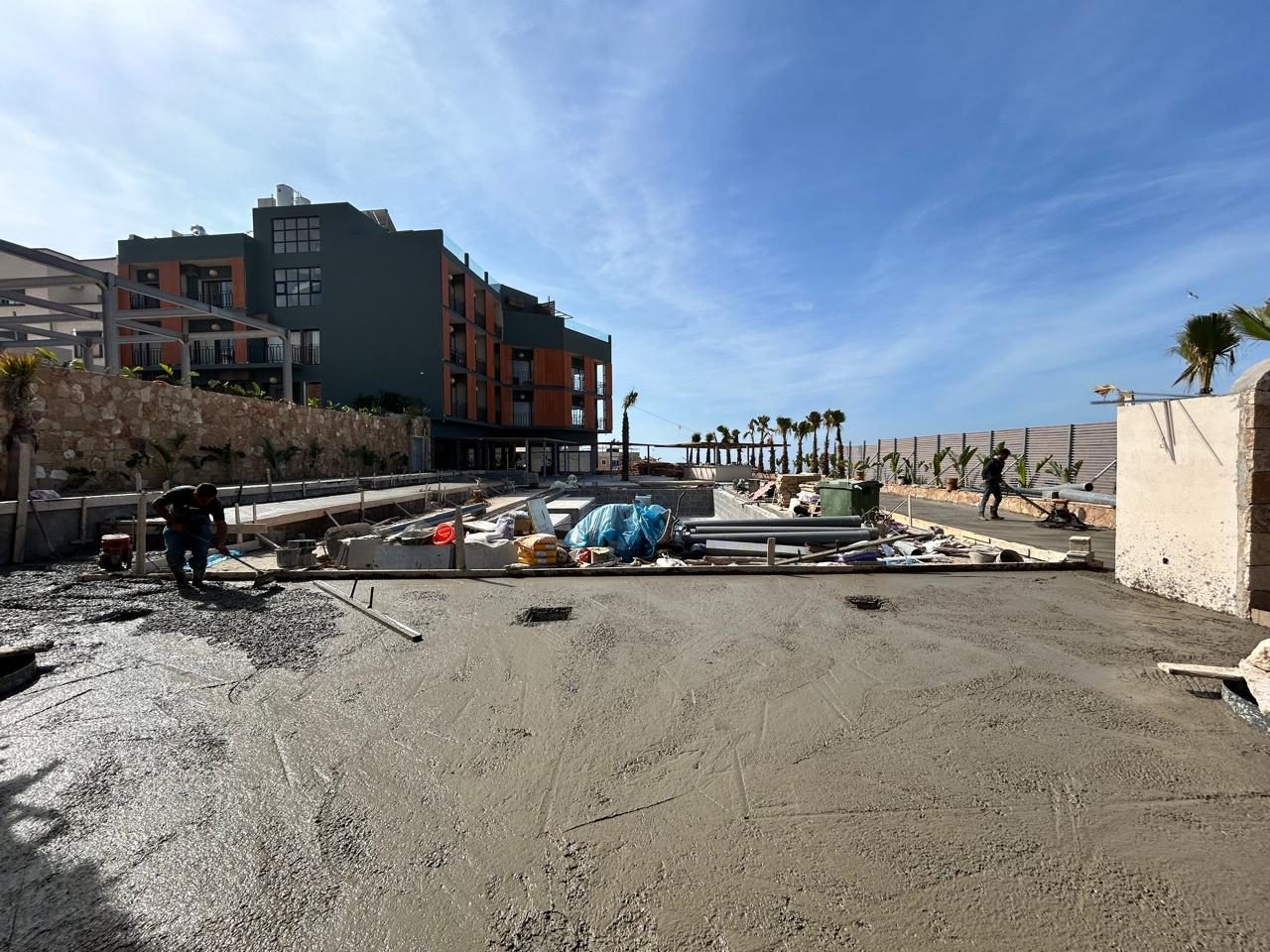 The hotel under construction, concrete being laid by the pool