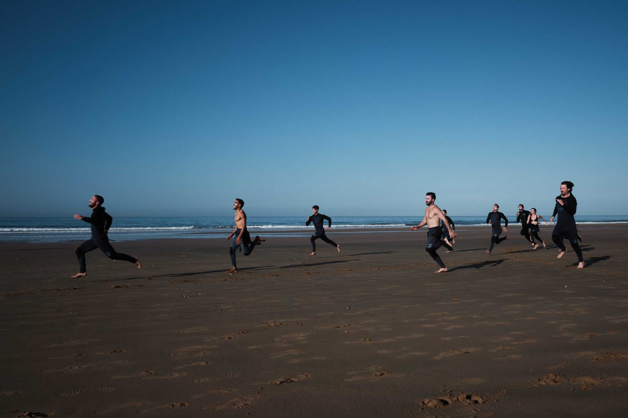 Surfers heading out across the beach at Tamraght, Taghazout Bay