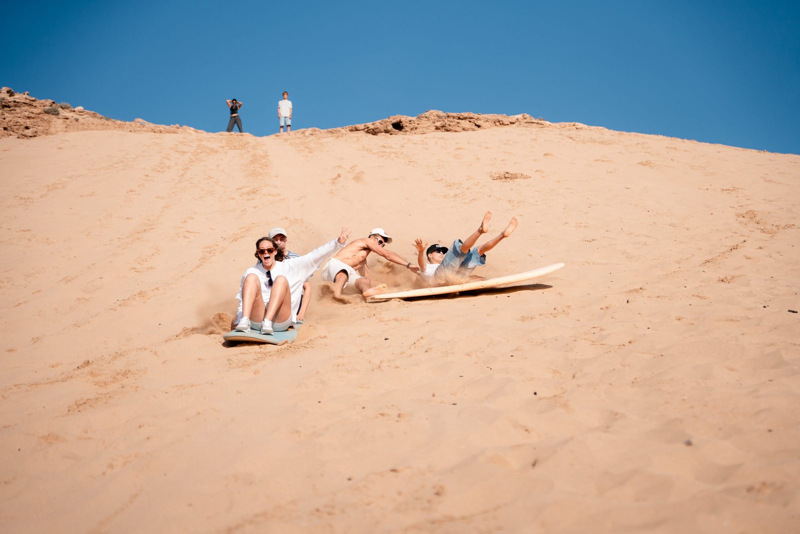 Resting on sandboards at the top of the dune